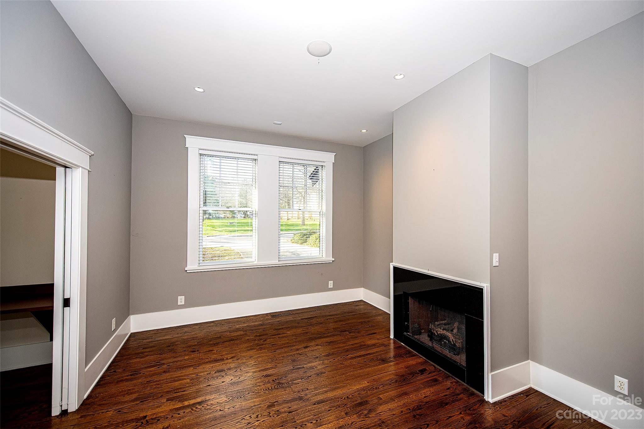1403 Devon Drive Charlotte, NC 28209 - Photo 22 of 46 a view of an empty room with wooden floor fireplace and a window