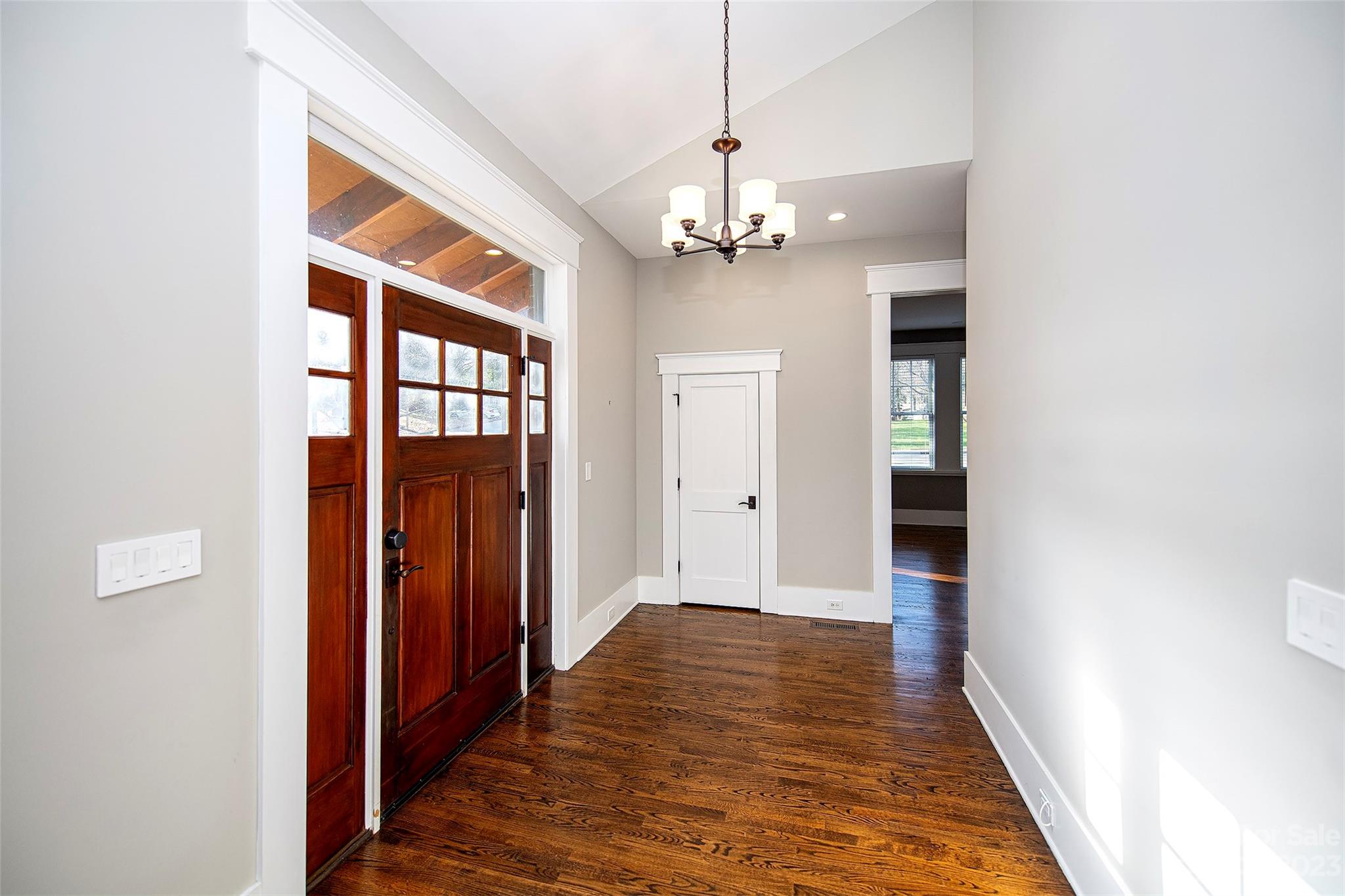 1403 Devon Drive Charlotte, NC 28209 - Photo 5 of 46 a view of a hallway with wooden floor and chandelier