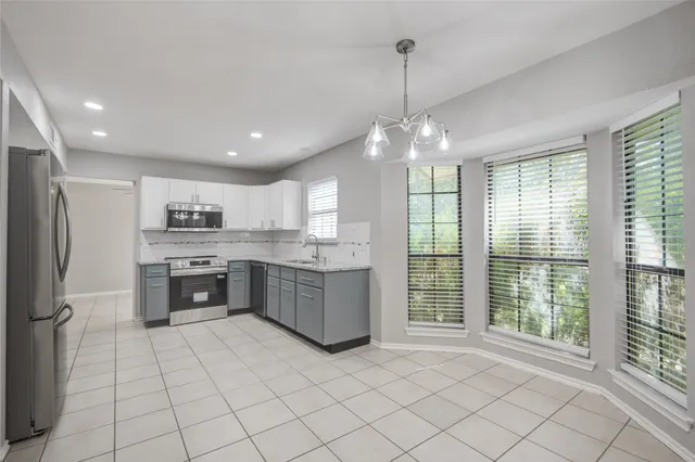 a large kitchen with kitchen island granite countertop a large counter top stainless steel appliances and cabinets