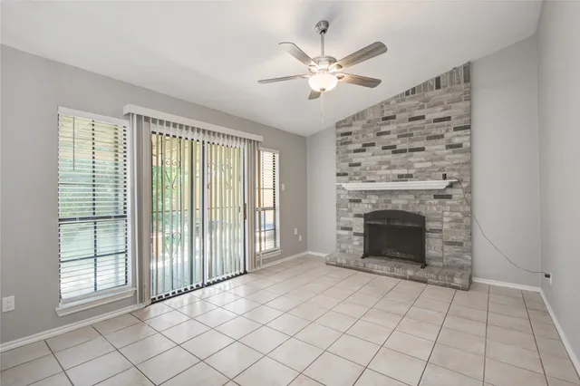 an empty room with fireplace and windows
