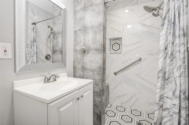 a bathroom with a sink a mirror and a shower