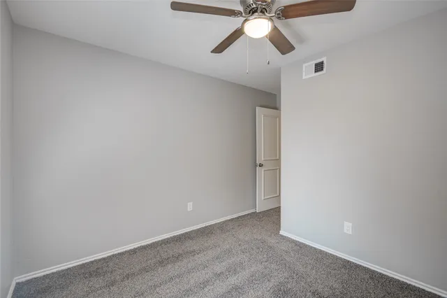 an empty room with a fan and a fan