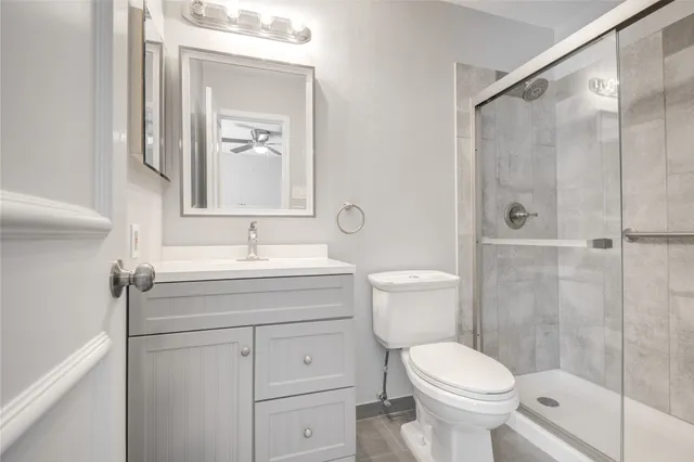 a bathroom with a sink toilet vanity and shower