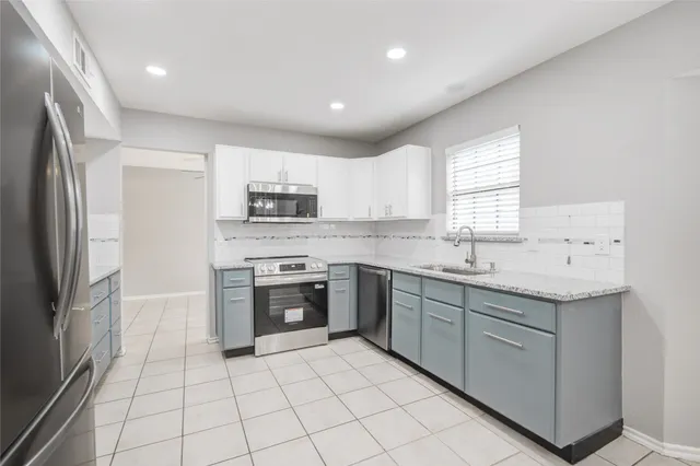 a kitchen with stainless steel appliances granite countertop a sink and a stove
