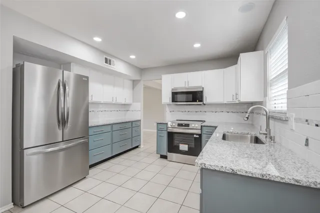 a kitchen with stainless steel appliances granite countertop a refrigerator sink and microwave