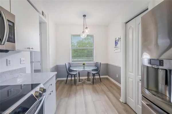 a kitchen with a table chairs a sink dishwasher and cabinets