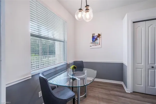a view of a dining room with furniture a chandelier and wooden floor