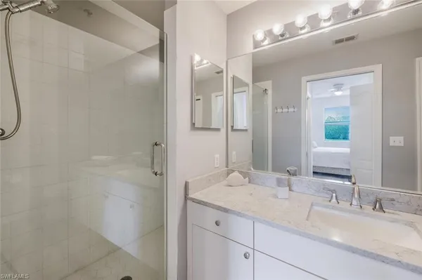 a bathroom with a granite countertop sink a shower and a mirror