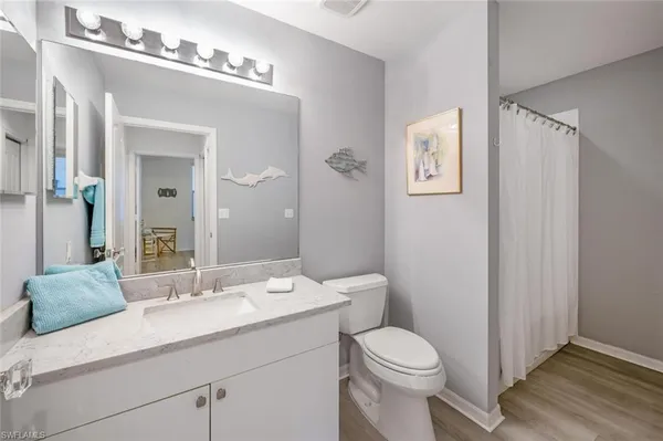 a bathroom with a granite countertop sink a toilet and a mirror