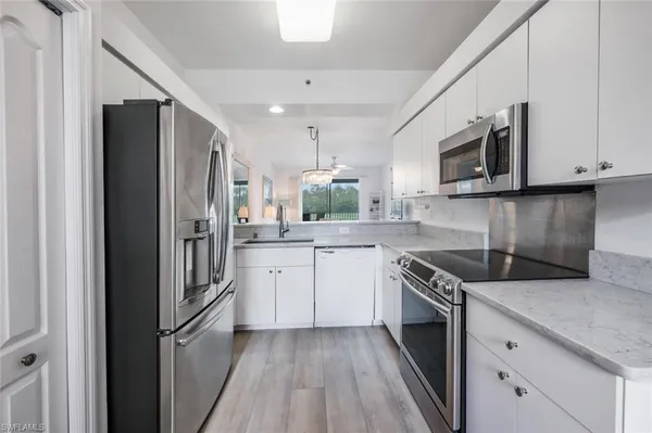 a kitchen with granite countertop a refrigerator stove and microwave