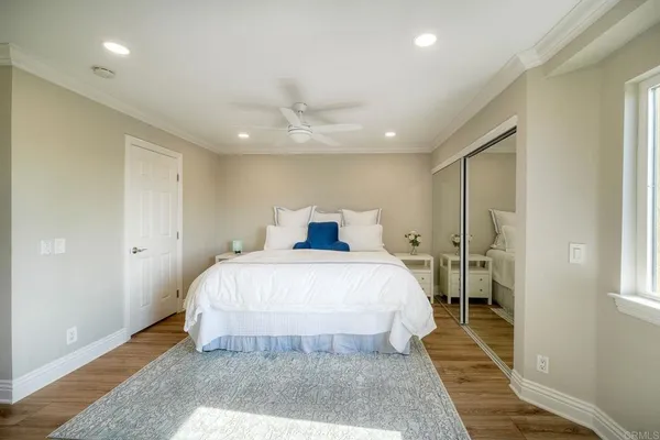 a bedroom with a large bed and a chandelier