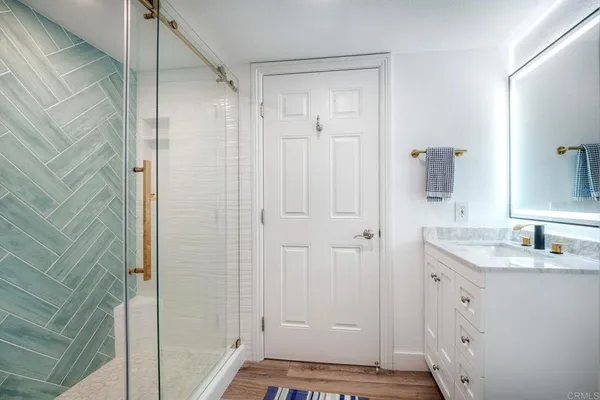 a bathroom with a granite countertop sink and shower