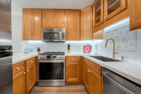 a kitchen with stainless steel appliances granite countertop a sink and a stove