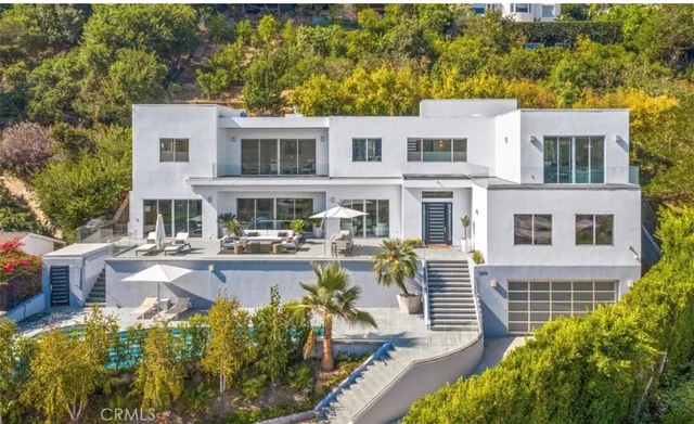 a front view of a house with swimming pool and sitting area