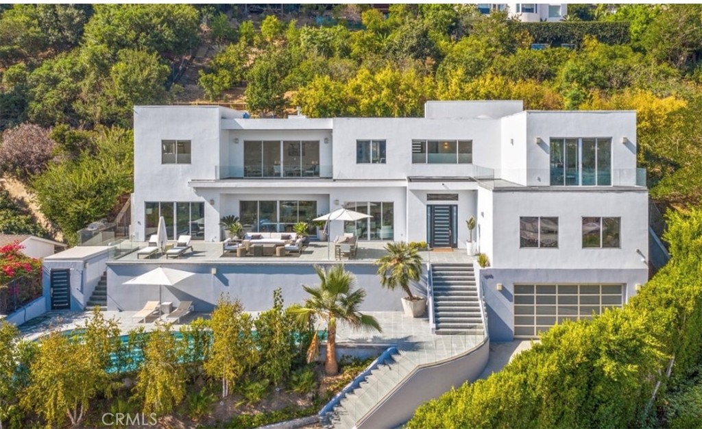 a front view of a house with swimming pool and sitting area