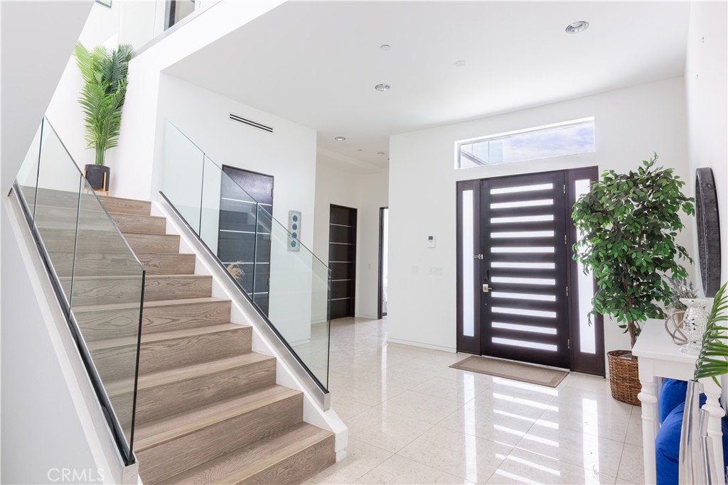 12148 Travis Street Los Angeles, CA 90049 - Photo 11 of 32 a view of staircase with lots of frames on wall and a potted plant