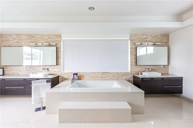 a spacious bathroom with a bathtub sink and mirror