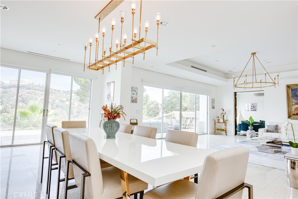 12148 Travis Street Los Angeles, CA 90049 - Photo 19 of 32 a view of a dining room with furniture large windows and wooden floor