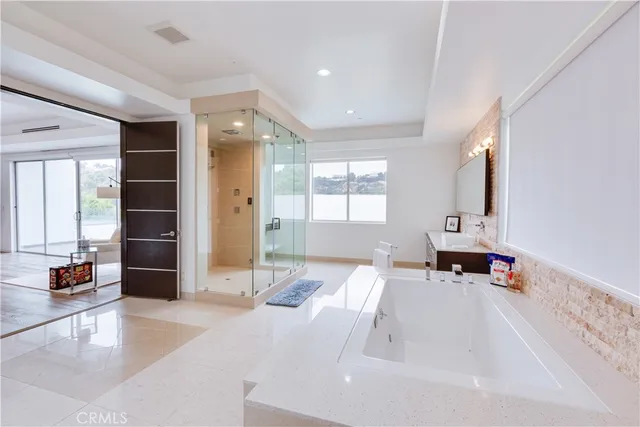 a large bedroom with a bed and large windows