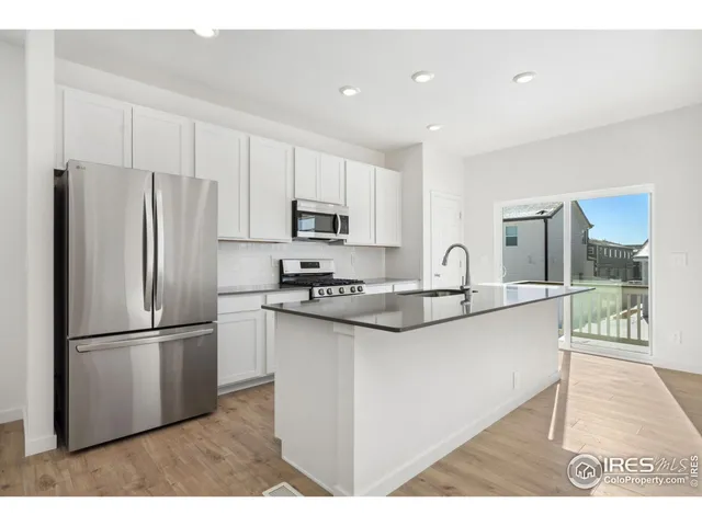 a kitchen with stainless steel appliances granite countertop a refrigerator sink and microwave