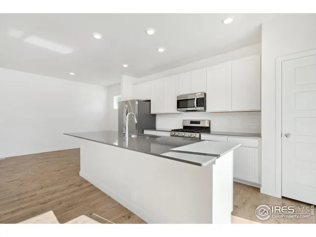 a kitchen with stainless steel appliances a sink stove and refrigerator