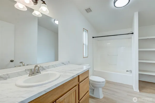 a bathroom with a granite countertop sink toilet a shower and a mirror