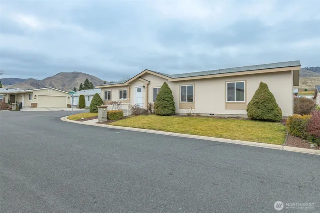 a view of a house with a big yard and large trees
