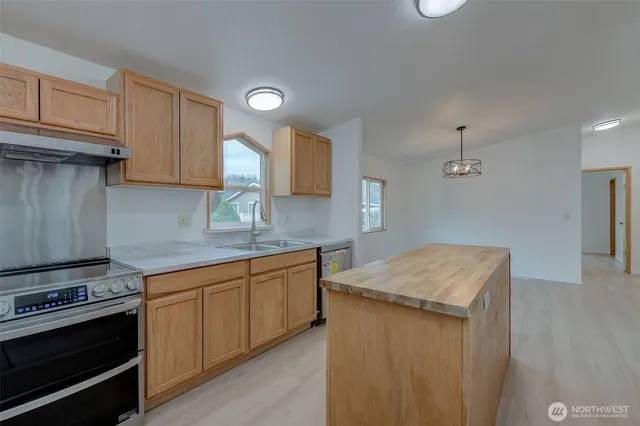 a kitchen with stainless steel appliances granite countertop a sink stove and cabinets