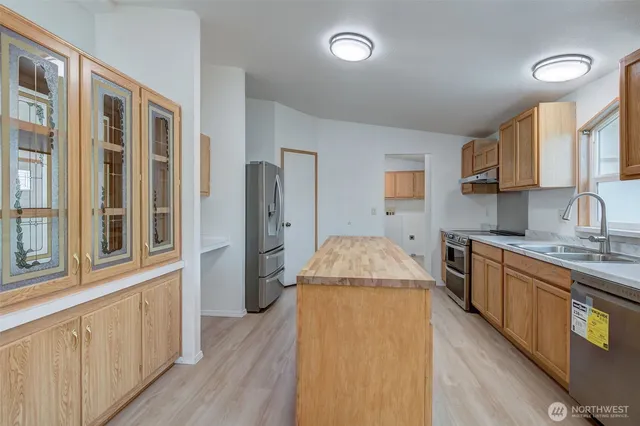 a kitchen with stainless steel appliances granite countertop a stove a sink and a refrigerator