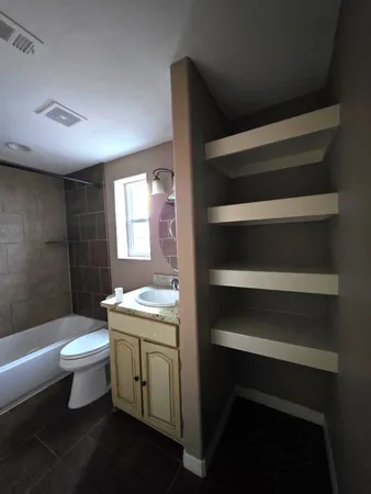 a bathroom with a toilet sink and mirror