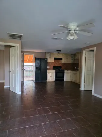 a view of a livingroom with furniture wooden floor and ceiling fan