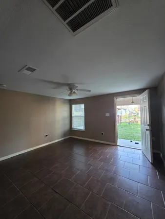 a view of an empty room with a fireplace and a window