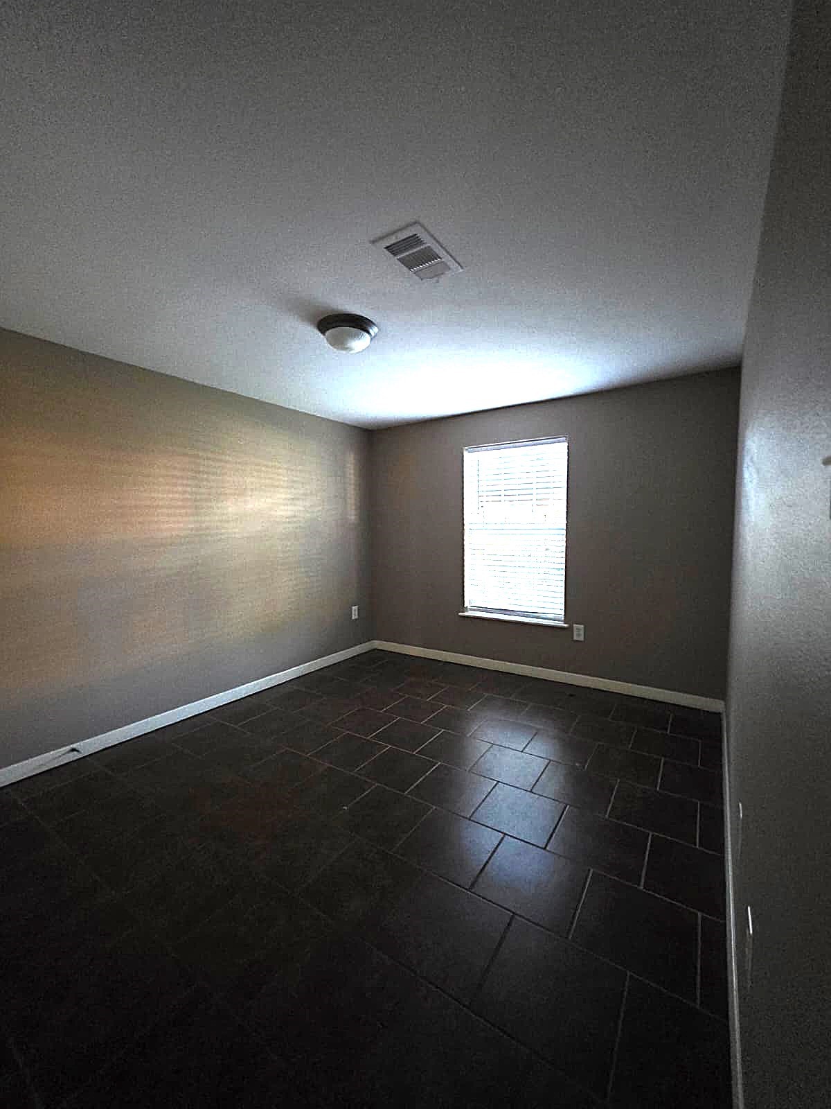 1720 Roxella Street Houston, TX 77093 - Photo 4 of 13 an empty room with wooden floor and windows