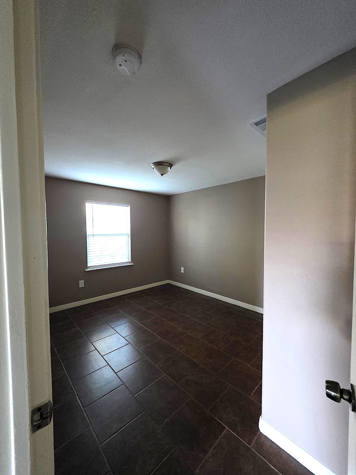 1720 Roxella Street Houston, TX 77093 - Photo 8 of 13 an empty room with wooden floor and windows