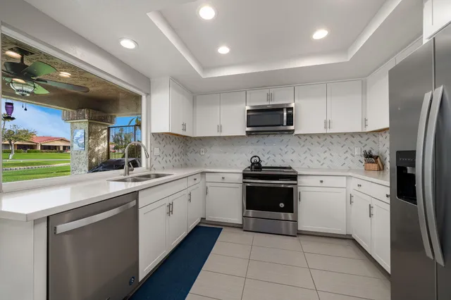 a kitchen with cabinets stainless steel appliances and a sink