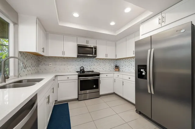 a kitchen with cabinets stainless steel appliances and a sink