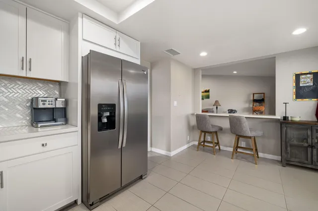 a kitchen with stainless steel appliances kitchen island granite countertop a refrigerator and a sink