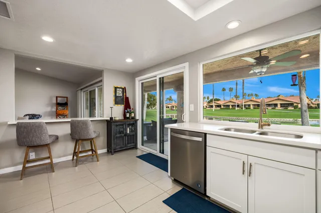 a kitchen with stainless steel appliances granite countertop a sink and a refrigerator