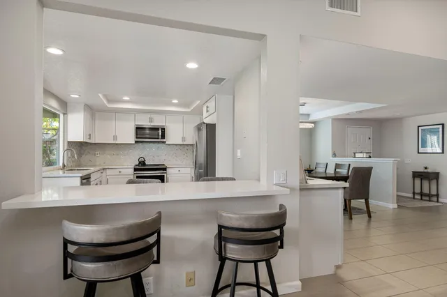 a kitchen with counter and chairs