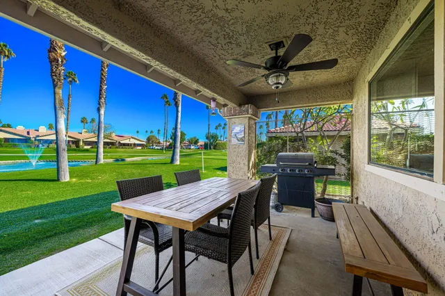 a view of a patio with a table chairs and a yard