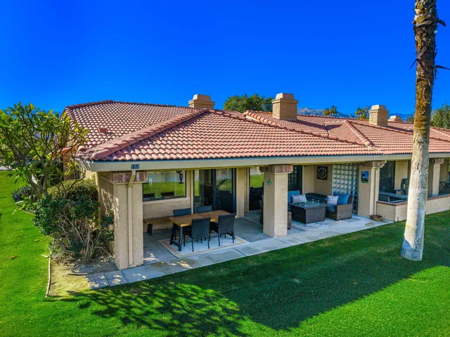 a view of a house with a yard patio and fire pit