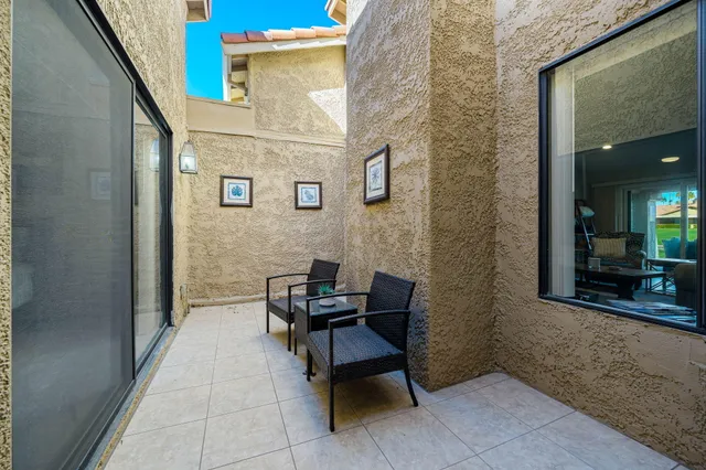 a view of a patio with chairs and a potted plant