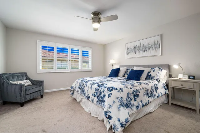 a bedroom with a bed couches chair and a window