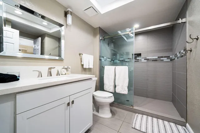a bathroom with a sink a toilet and shower