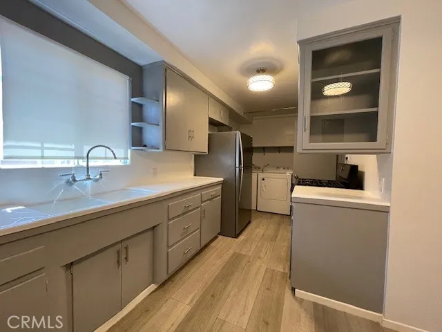 a kitchen with sink a refrigerator and cabinets