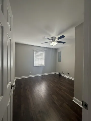 a view of empty room with wooden floor and window