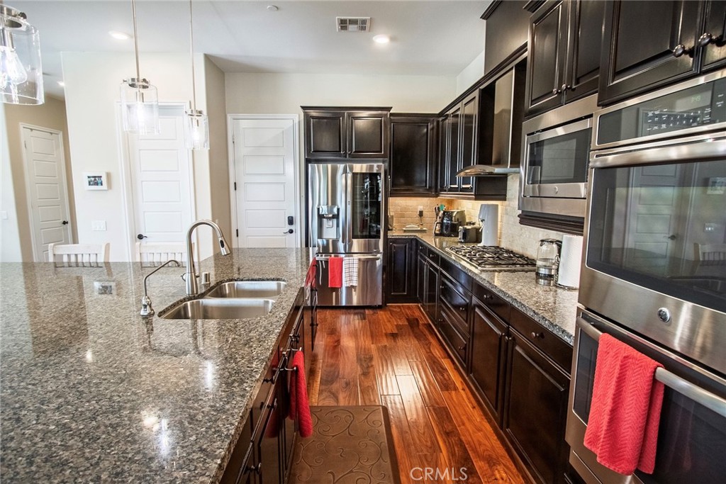 26424 Township Street Saugus, CA 91350 - Photo 16 of 72 a kitchen with stainless steel appliances granite countertop a sink stove and refrigerator