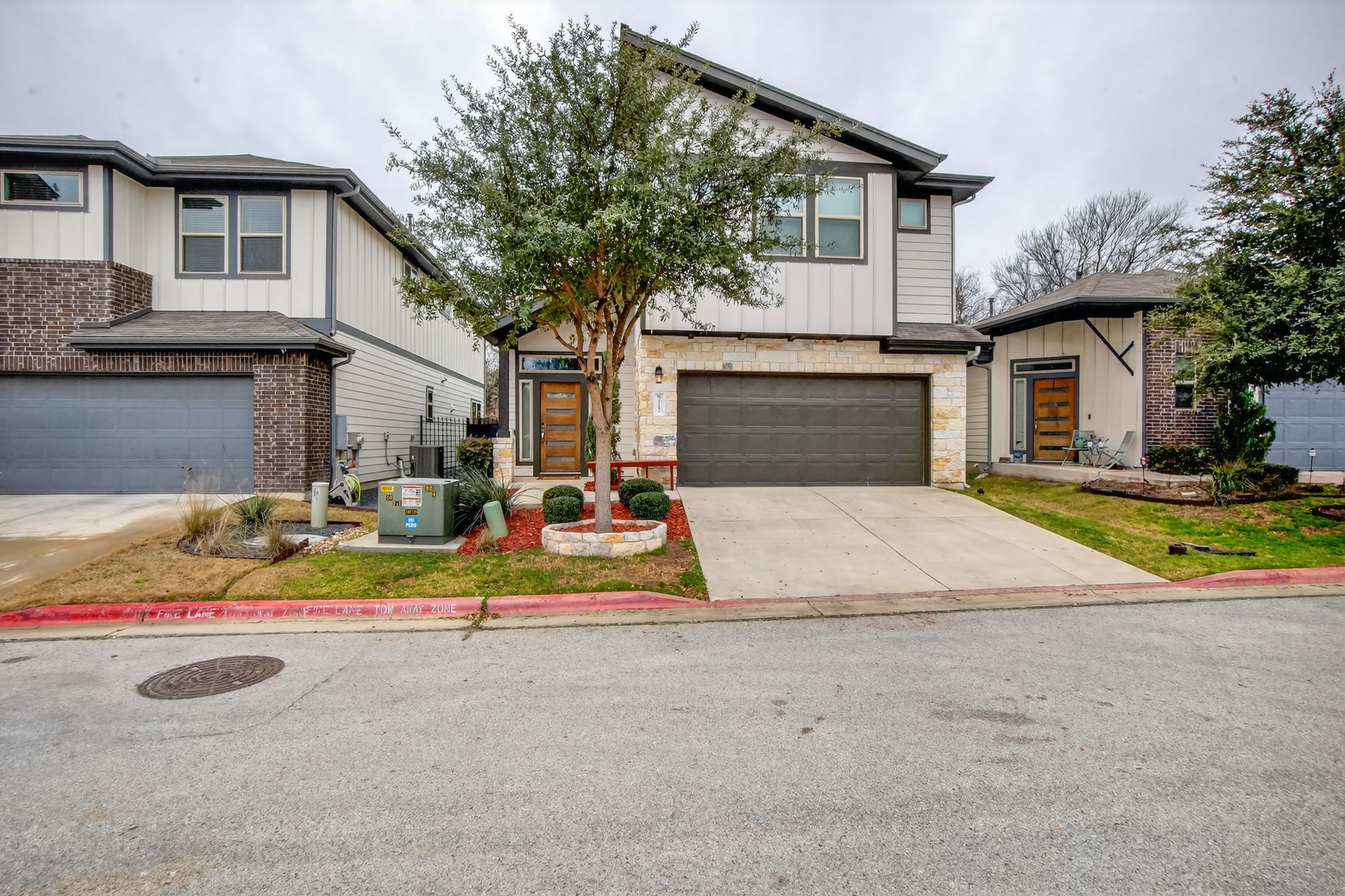 View of front facade with an attached garage, concrete driveway, and stone siding