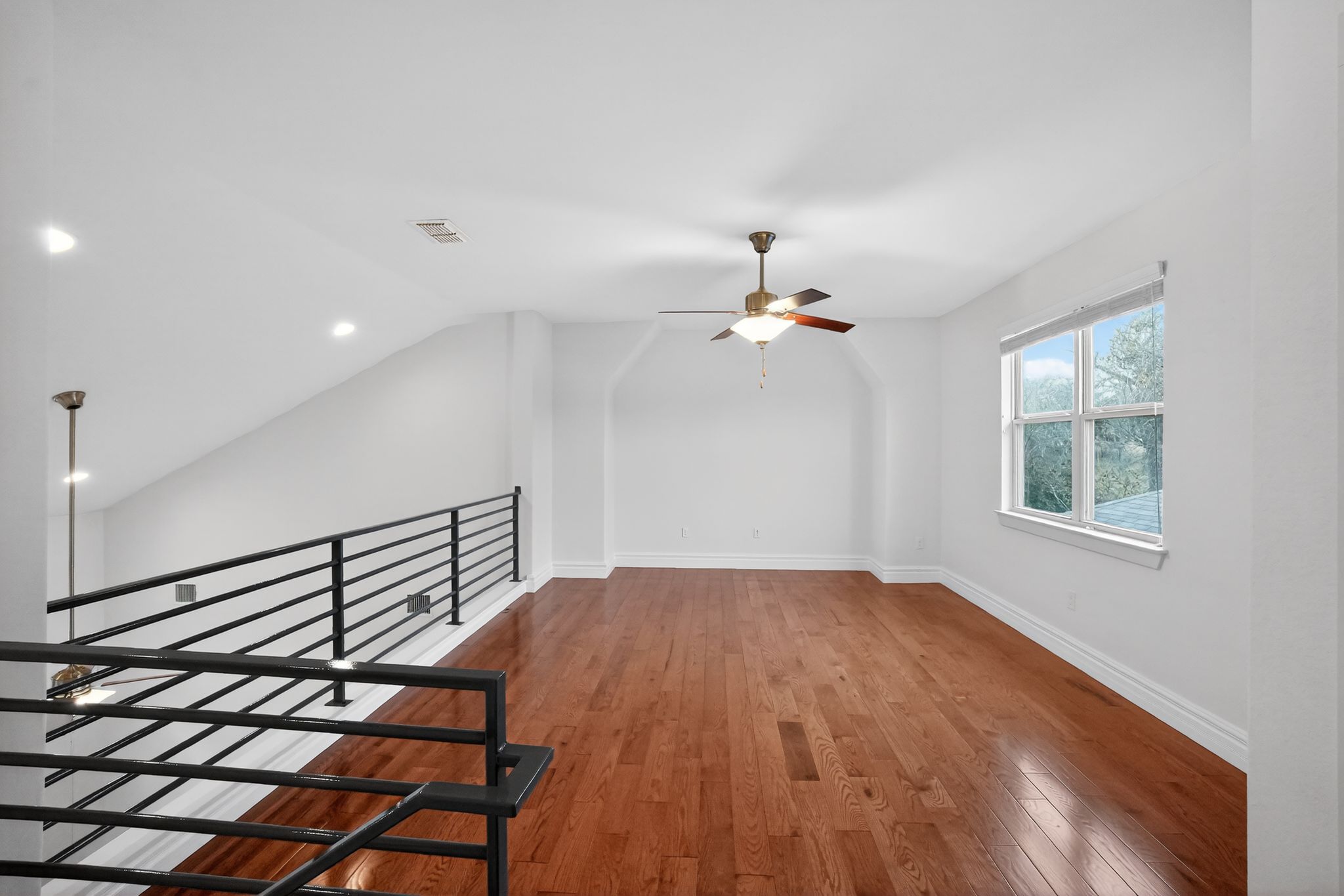 9717 Briny Shell Way Austin, TX 78748 - Photo 11 of 16 Additional living space featuring hardwood / wood-style floors, a ceiling fan, and vaulted ceiling
