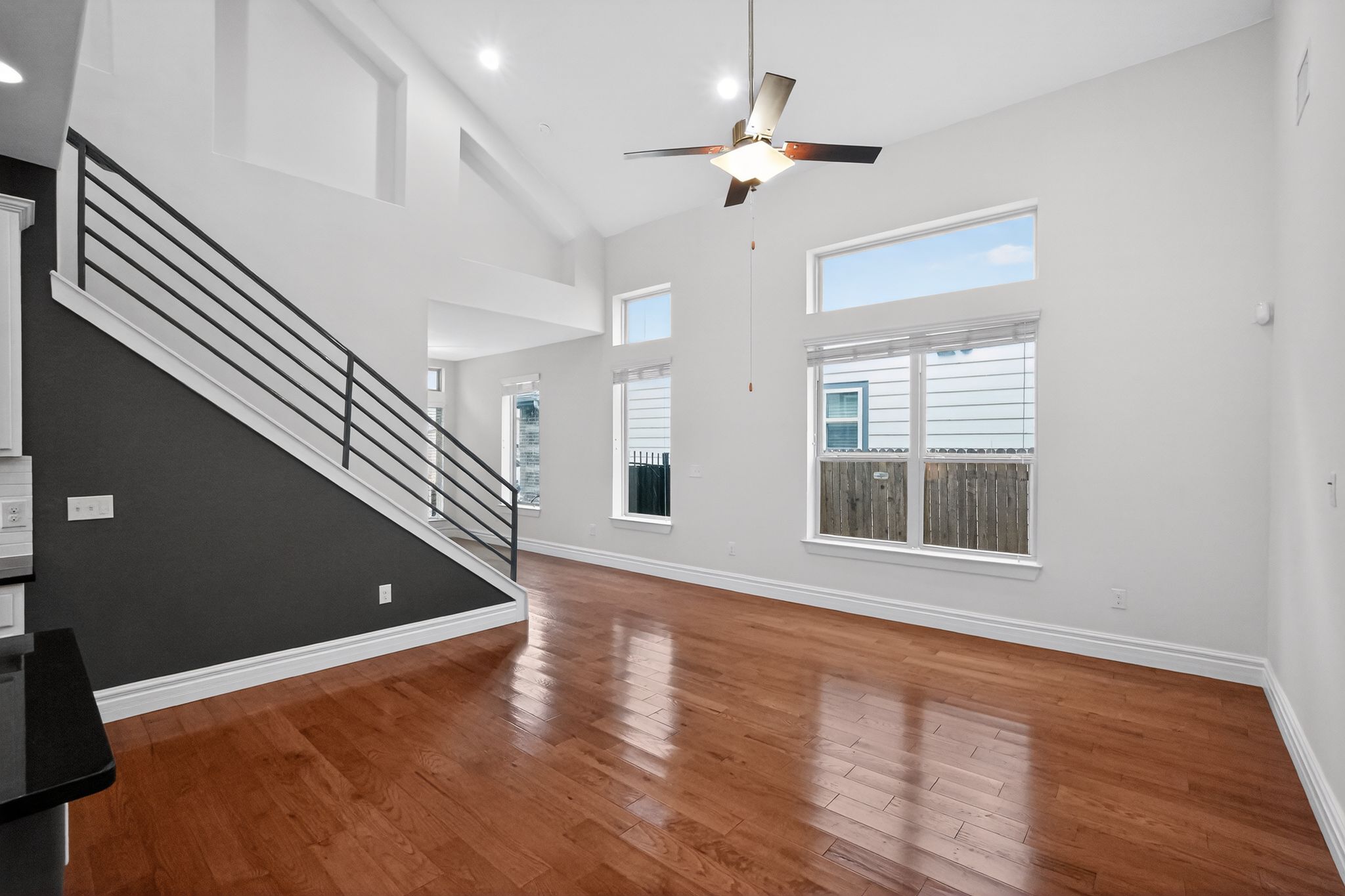9717 Briny Shell Way Austin, TX 78748 - Photo 3 of 16 Unfurnished living room featuring wood-type flooring, a ceiling fan, recessed lighting, and lofted ceiling